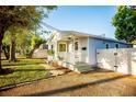 Quaint home featuring a welcoming front porch, lush lawn, and a private gated entrance at 6906 N Central Ave, Tampa, FL 33604