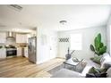 Inviting living room and kitchen area, featuring stainless steel appliances and a comfortable seating area at 6906 N Central Ave, Tampa, FL 33604