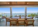 Waterfront patio with a large wooden table, seating for eight, and stunning water views at 6976 S Shore S Dr, St Petersburg, FL 33707