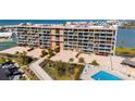 Exterior view of condominium complex with landscaping, pool, and bayside location at 1 Key Capri # 604W, Treasure Island, FL 33706