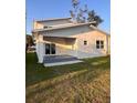 Backyard featuring covered patio, sliding glass door, and well-maintained lawn at 1030 11Th S Ave, St Petersburg, FL 33705