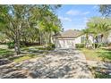 Inviting home featuring a spacious driveway, well-maintained lawn, mature trees, and manicured hedges adding to its curb appeal at 12227 Glencliff Cir, Tampa, FL 33626