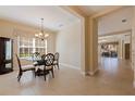 Elegant dining room featuring a glass-top table, decorative chandelier, and ample natural light, ideal for gatherings at 13574 Circa Crossing Dr, Lithia, FL 33547