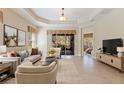 Bright, spacious living room with neutral tones, plush furnishings, and large windows leading to an outdoor space at 13574 Circa Crossing Dr, Lithia, FL 33547