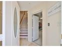 Inviting home foyer with stairs, garage access, and elegant coastal decor at 140 Brightwater Dr # 1, Clearwater Beach, FL 33767