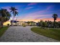 Stunning waterfront home with lush landscaping, circular driveway and captivating sunset views at 173 1St W St, Tierra Verde, FL 33715