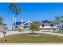 Beautiful home boasts lush landscaping, a circular driveway and a modern, clean exterior design at 173 1St W St, Tierra Verde, FL 33715