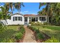 Charming white home with a well-kept lawn, beautiful landscaping, and a welcoming walkway at 209 17Th N Ave, St Petersburg, FL 33704