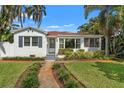 Inviting white home featuring a manicured lawn, lush landscaping, and a charming front entrance at 209 17Th N Ave, St Petersburg, FL 33704