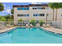 Community pool with lounge chairs, tables, and umbrellas providing a relaxing outdoor space at 209 Ne Lincoln N Cir # 105, St Petersburg, FL 33702