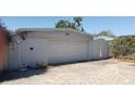 Image of a detached one-car garage with a brick driveway and a wooden gate at 2107 S West Shore Blvd, Tampa, FL 33629