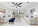 Open living room featuring tile flooring, ceiling fan, and a view into the kitchen and dining area at 2401 E Cayuga St, Tampa, FL 33610