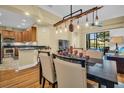Open-concept dining and living area with wooden floors, modern lighting fixtures, and stainless steel kitchen appliances at 2537 Gloriosa Dr # 2, Palm Harbor, FL 34684