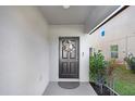 A welcoming front entrance featuring a stylish wreath on a dark-colored door, complemented by lush greenery and well-maintained landscaping at 36312 Garden Wall Way, Zephyrhills, FL 33541