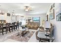 Bright, open-concept living space with tile floors, neutral tones, modern furniture and a seamless flow to the dining area at 36312 Garden Wall Way, Zephyrhills, FL 33541