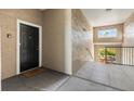Hallway leading to a unit entrance with a black door and adjacent staircase at 4209 Woodstorks Walk Way # 1304, Lutz, FL 33558