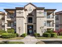 Condo building with multiple balconies, attractive landscaping, and common access stairs at 4209 Woodstorks Walk Way # 1304, Lutz, FL 33558