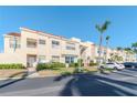Beautiful two-story condo with a manicured lawn, parking, and swaying palm trees on a bright sunny day at 6100 Bahia Del Mar Cir # 102, St Petersburg, FL 33715