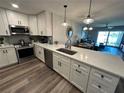 Lovely kitchen featuring stainless steel appliances, white cabinets and a large island with stunning gray countertops at 6100 Bahia Del Mar Cir # 102, St Petersburg, FL 33715