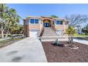 Gorgeous home featuring a grand staircase leading to the front door and attached garages at 733 Seminole Blvd, Tarpon Springs, FL 34689
