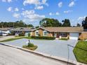 Well-maintained single-story home with a long driveway, attached garage, and mature landscaping at 7505 Exter Way, Tampa, FL 33615