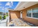 Charming front entrance with decorative lanterns, a white door, and colorful paver flooring at 7505 Exter Way, Tampa, FL 33615
