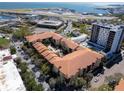 Aerial view showcases the property's layout with a central courtyard, pool, parking, and proximity to the water and airport at 100 4Th S Ave # 208, St Petersburg, FL 33701