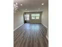 Bright, updated living room with a chandelier, new floors, updated baseboards, and lots of natural light at 1000 49Th N St # 309, St Petersburg, FL 33710