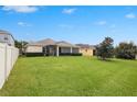 Expansive backyard with lush green grass, mature landscaping, and a fence, offering ample space for recreation at 11218 Coventry Grove Cir, Lithia, FL 33547