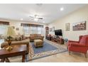 Comfortable living room featuring neutral tones, ceiling fan, tile floors, and large windows at 11218 Coventry Grove Cir, Lithia, FL 33547
