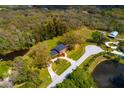 Aerial view showcasing a brick home surrounded by lush greenery and two picturesque ponds at 12603 Corral Rd, Tampa, FL 33626
