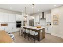 A modern kitchen features white cabinets, a center island with seating, and stainless steel appliances at 12785 Jade Empress Loop # 102, Venice, FL 34293