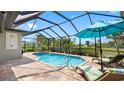 A screened-in pool with outdoor seating offers the perfect place to relax and enjoy the Florida sunshine at 135 Cabana Way, Rotonda West, FL 33947