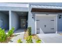 This townhome features a one-car garage, a covered entry, and rock landscaping at 14477 Editors Note St, Ruskin, FL 33573