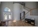 Elegant foyer featuring tile flooring, high ceilings, decorative entry doors, and staircase to the second level at 17923 Timber View St, Tampa, FL 33647