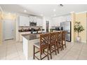Bright kitchen with granite countertops, an island with seating, and white cabinetry at 17950 Beaming Rays Ln, Lutz, FL 33558