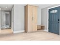 Entryway featuring a mudroom style cabinet, wood floors, and a recently painted blue door at 1972 Sourwood Blvd, Dunedin, FL 34698