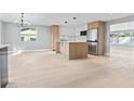 Open-concept kitchen and living room featuring stainless steel appliances, wood floors, and modern finishes at 1972 Sourwood Blvd, Dunedin, FL 34698