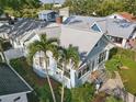 Aerial view of a light blue home surrounded by greenery and neighboring houses, showcasing its roof and landscaping at 210 15Th N Ave, St Petersburg, FL 33704