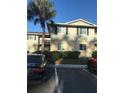 Well-maintained two-story condo featuring neutral siding, black shutters, and a mature palm tree at 224 Red Maple Pl # 224, Brandon, FL 33510