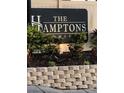Community sign for The Hamptons Condominiums, set amidst lush landscaping and brickwork at 224 Red Maple Pl # 224, Brandon, FL 33510