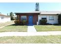 Well-maintained single story home featuring a blue front door, red brick, and lush green lawn at 24862 Us Highway 19 N # 2801, Clearwater, FL 33763