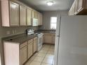 Functional kitchen featuring ample cabinet space, white appliances, and neutral tile flooring at 3112 E 8Th Ave, Tampa, FL 33605