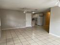 Open-concept living room with neutral tile flooring, ceiling fans, and access to the kitchen at 3112 E 8Th Ave, Tampa, FL 33605