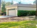 Attached two-car garage with lush landscaping offering privacy to the side of the house at 3358 Tanglewood Trl, Palm Harbor, FL 34685