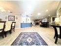 Bright and open living space with wood-look tile flooring, skylight, and open access to other rooms at 3358 Tanglewood Trl, Palm Harbor, FL 34685