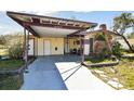 A tan single-story house with a covered carport and a brick chimney at 4002 W Gray St, Tampa, FL 33609