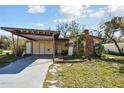 Charming single-story home featuring a carport, brick chimney and quaint front yard at 4002 W Gray St, Tampa, FL 33609