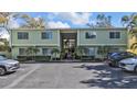 A condo building with a shared parking lot, landscaping, and muted green facade at 445 S Palm Ave # 3, Sarasota, FL 34236