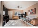 Bright living room with neutral paint, tile floors, ceiling fan, and comfortable seating at 4535 Kennewick Pl, Riverview, FL 33578